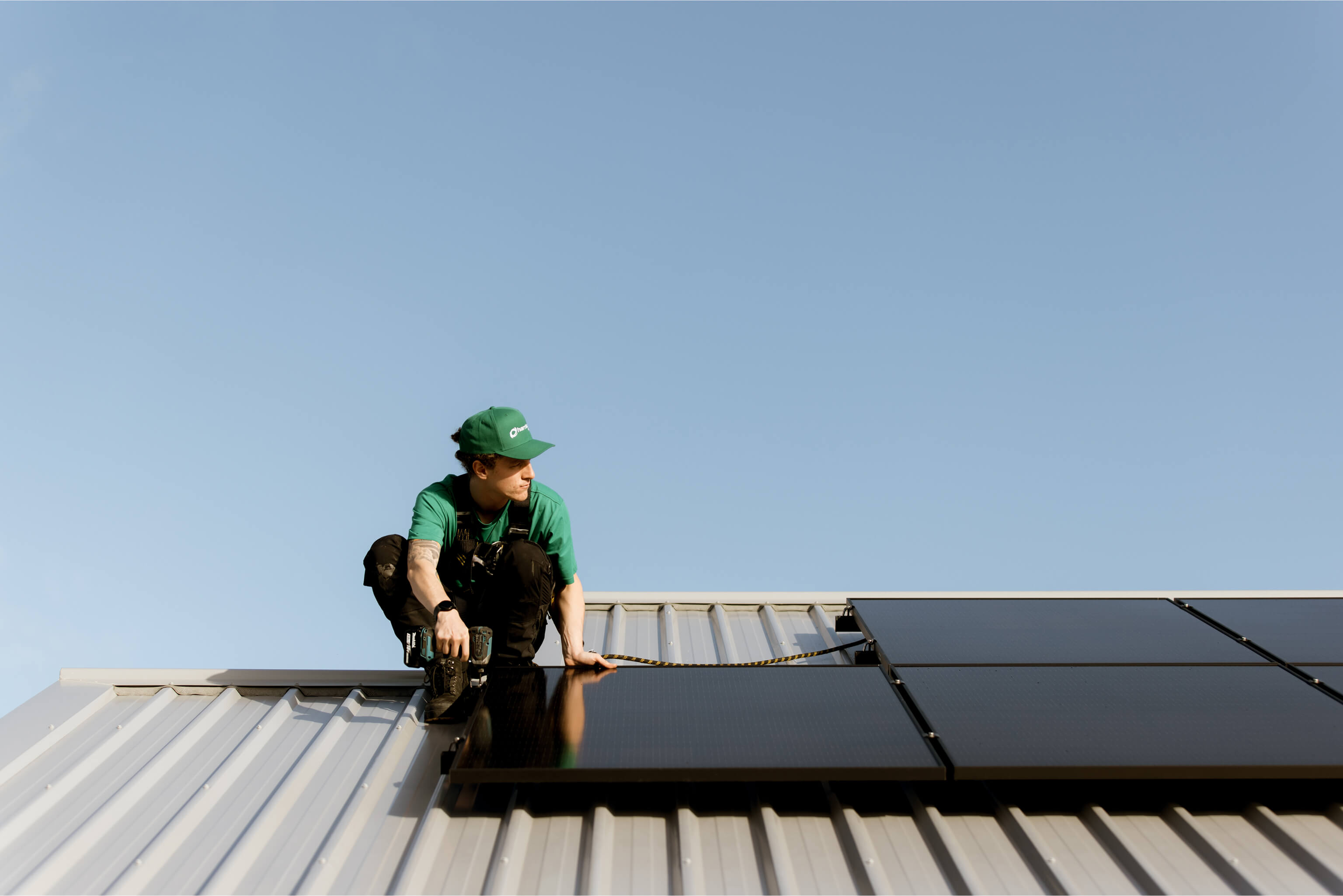 A Harrisons Solar team member installing solar panels on a clients roof.