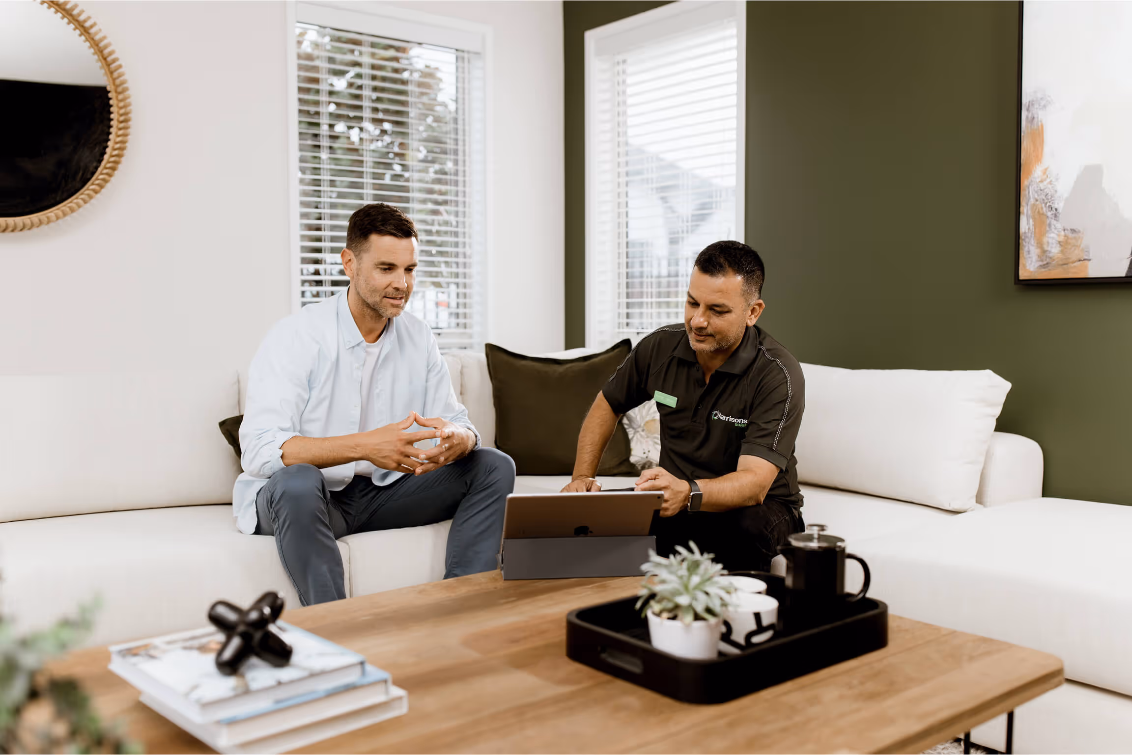 Harrison solar team member sitting with a client in their home discussing their solar options.