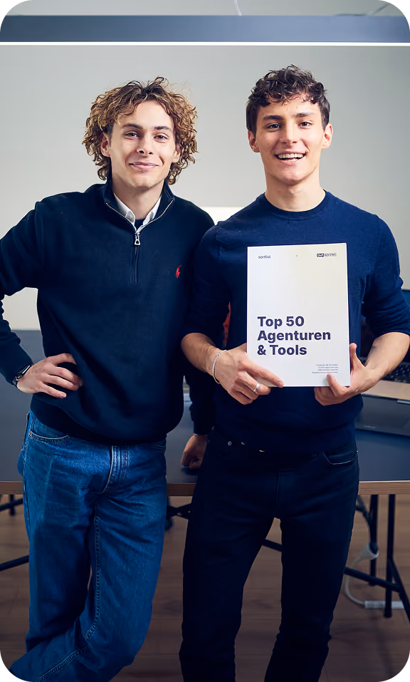 Die THEFABERS Gründer Emil und Elia halten stolz den OMR X Sortlist Guide Top 50 Agenturen & Tools in den Händen
