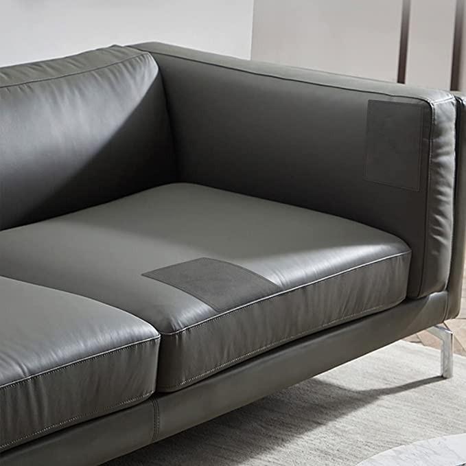 Canapé en simili cuir noir avec deux patchs visibles sur l’assise et le dossier, utilisés pour tester un kit de réparation du simili cuir.