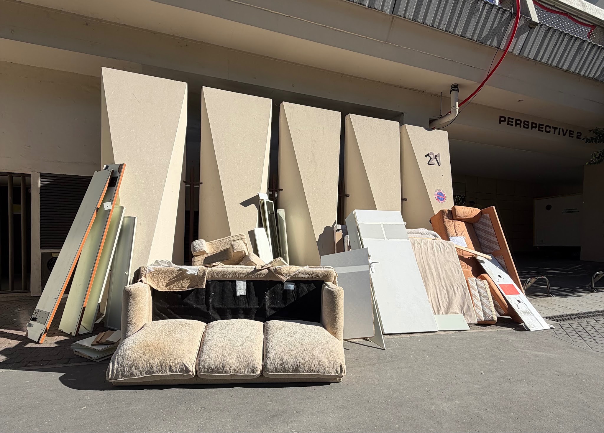 Canapé abandonné sur le trottoir illustrant le gaspillage de meubles.