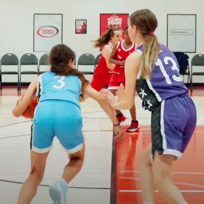 A basketball player driving against a defender