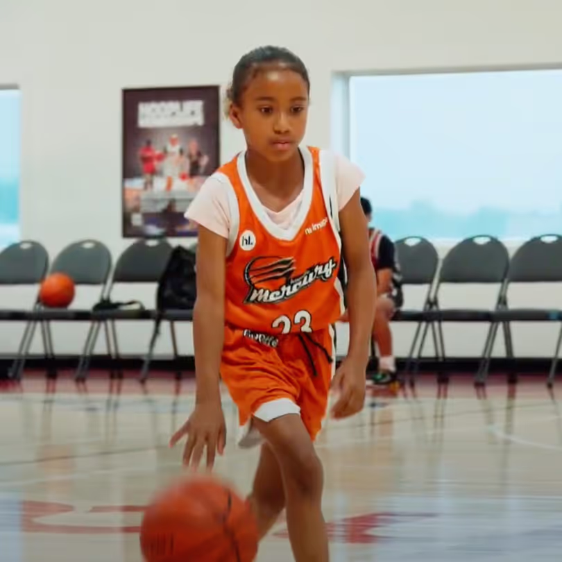 Girl dribbling a basketball down the court