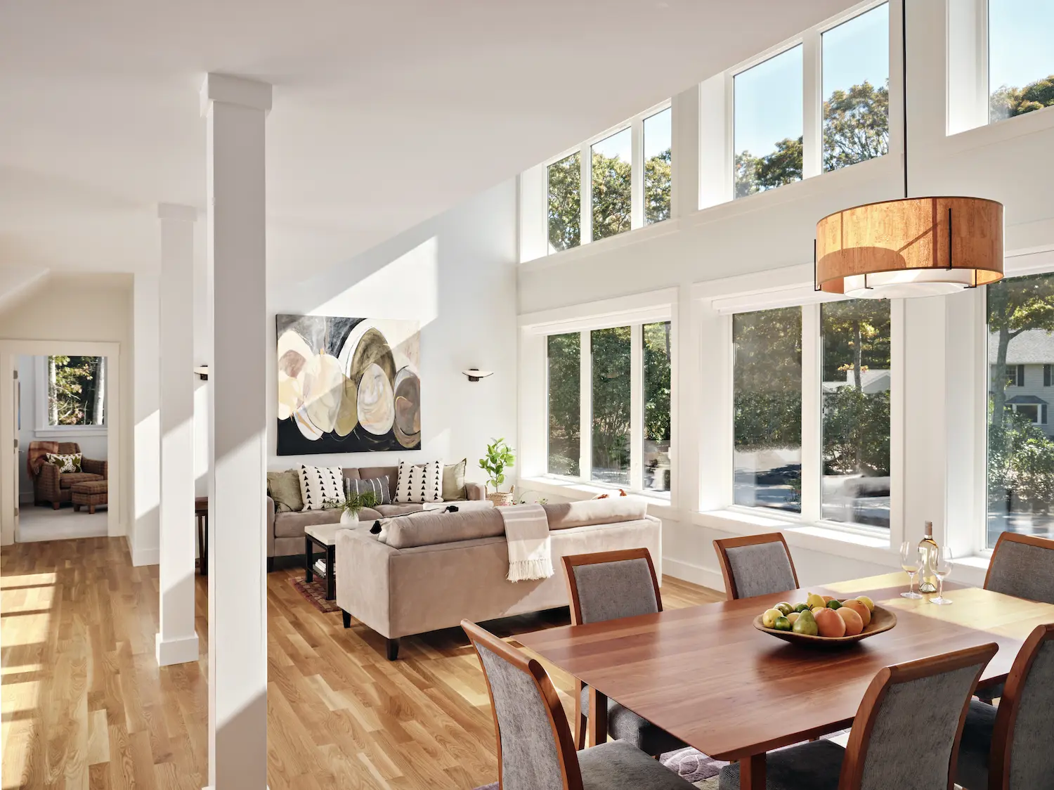 Bright, airy living space with large windows, dining table, and modern furniture