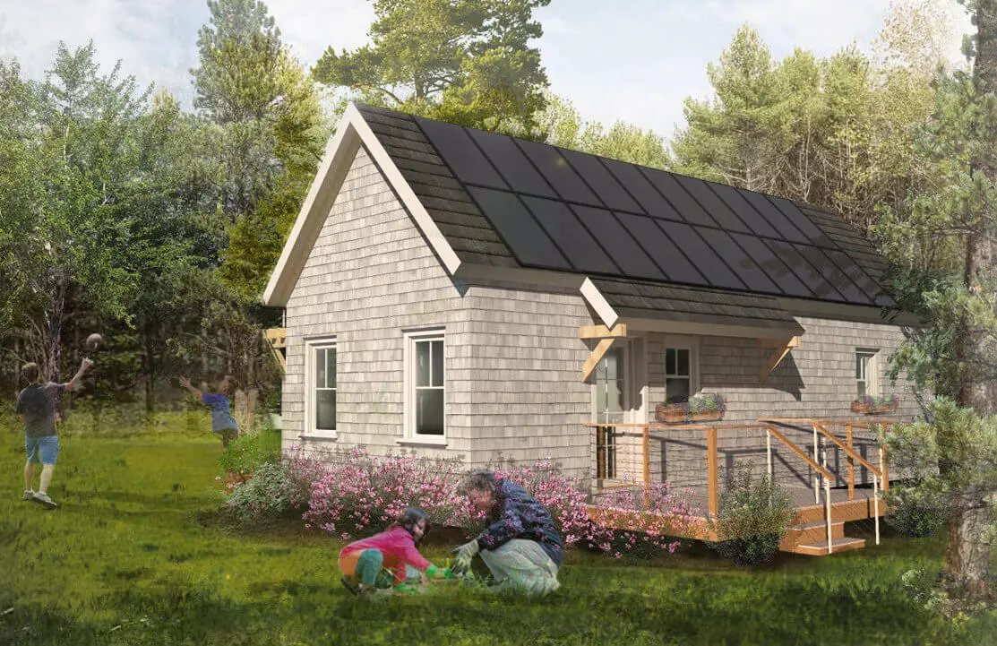 Solar-powered cottage with wooden deck, surrounded by green lawn and trees