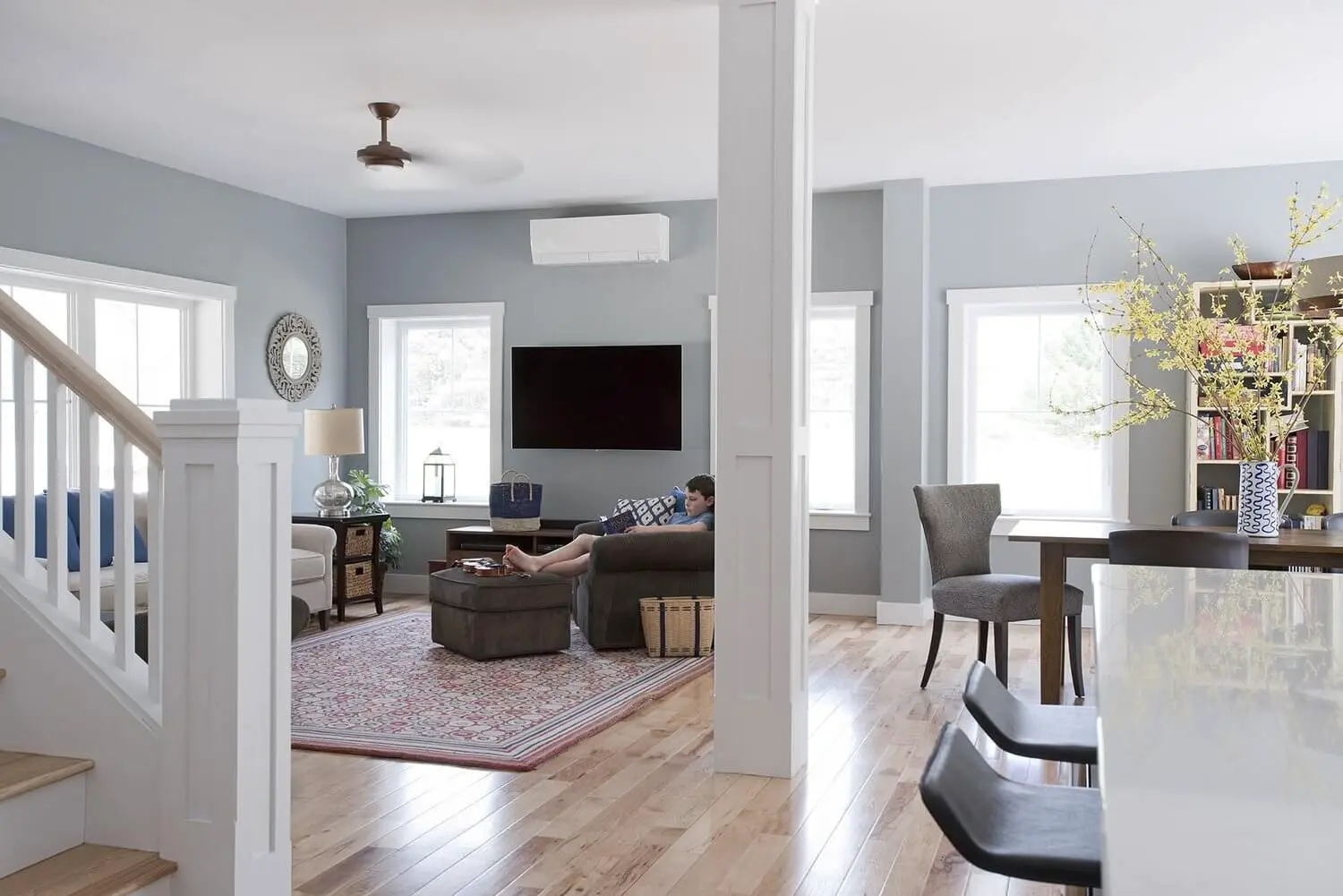Modern open-concept living room with gray walls and wooden floors