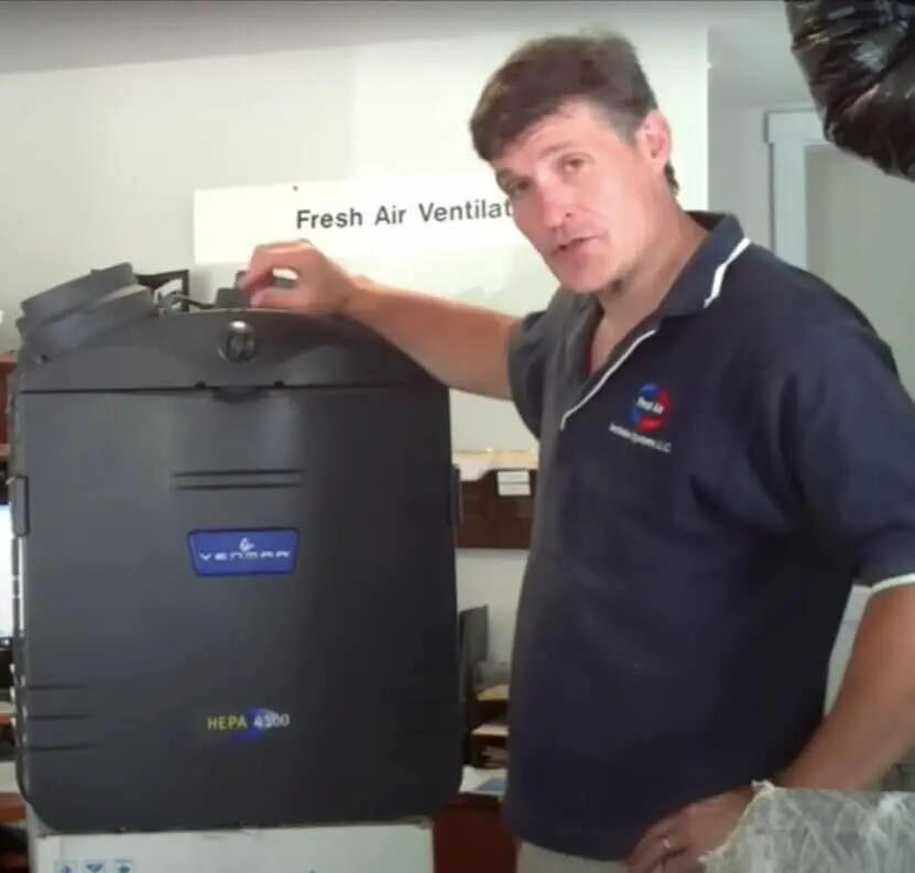 Technician standing next to a Venmar fresh air ventilation system