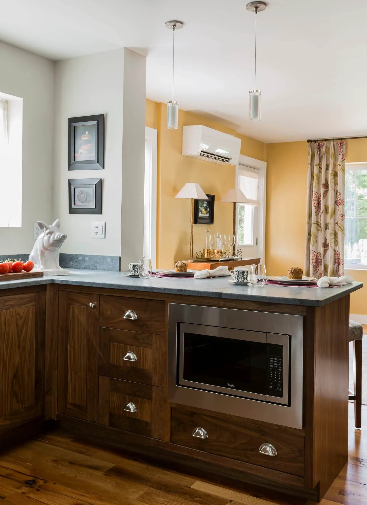 Modern kitchen with wooden island, yellow walls, and table setting