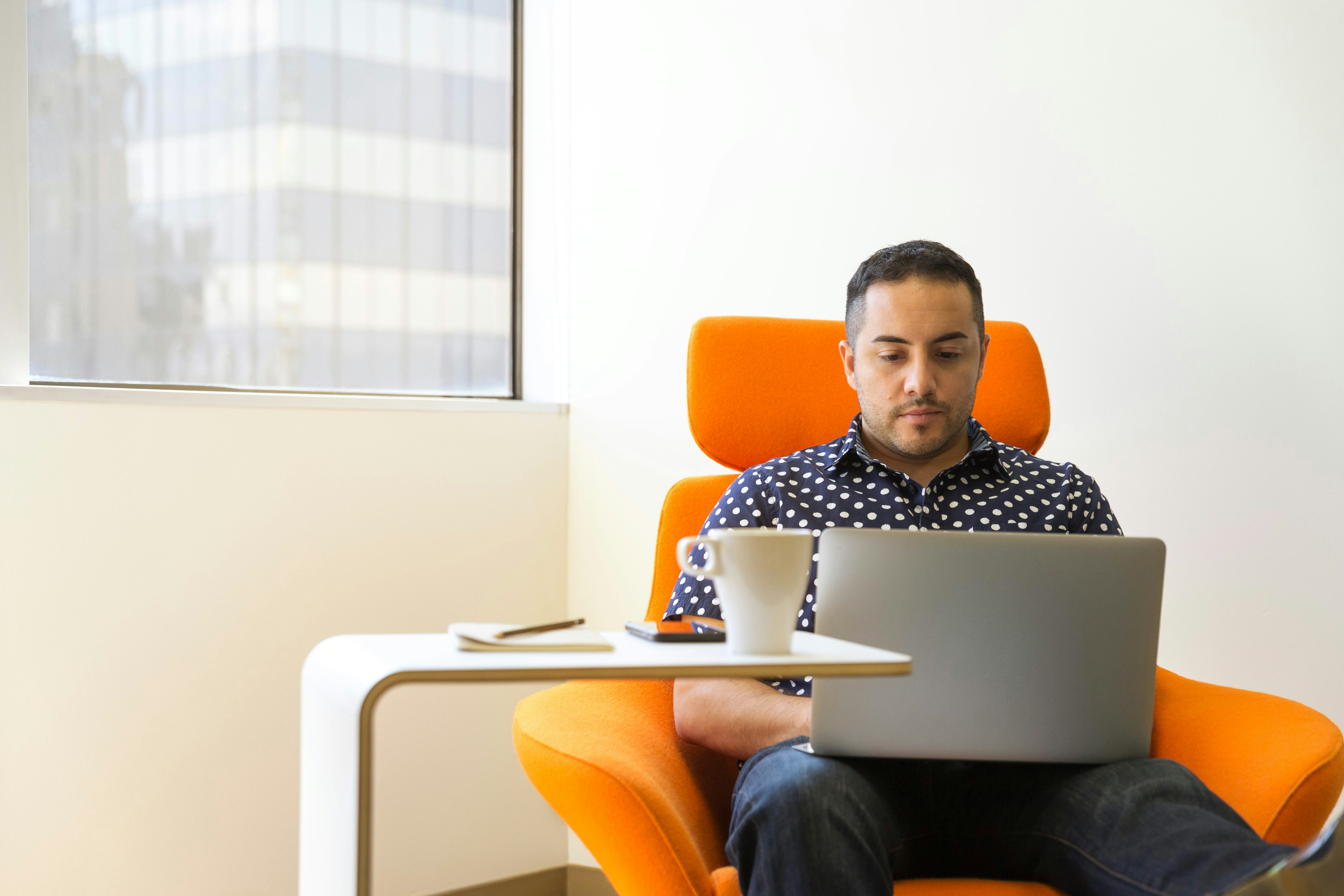 man sitting on sofa with laptop following software release management best practices