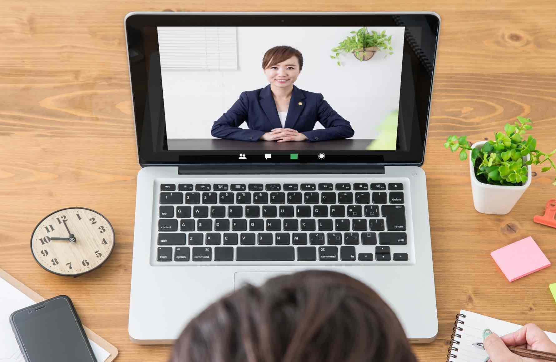 Person taking notes during an online video call with a professional