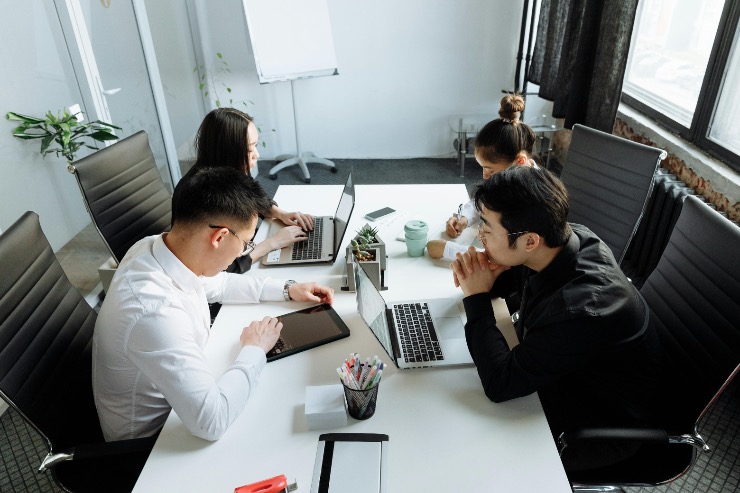 Interns working together on laptops in a modern office space