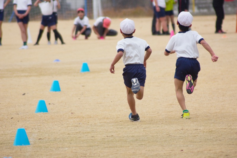 Japanese children in sports uniforms running during school sports day
