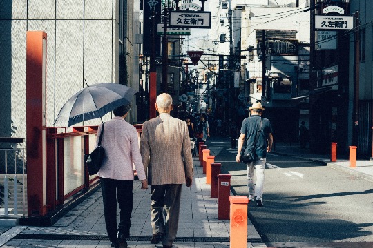 Elderly couple walking through a quiet street in Japan