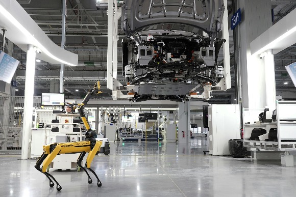 Robot dog assisting in a modern car factory