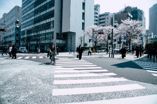 Pedestrians and cyclists crossing an intersection in a modern Japanese business district