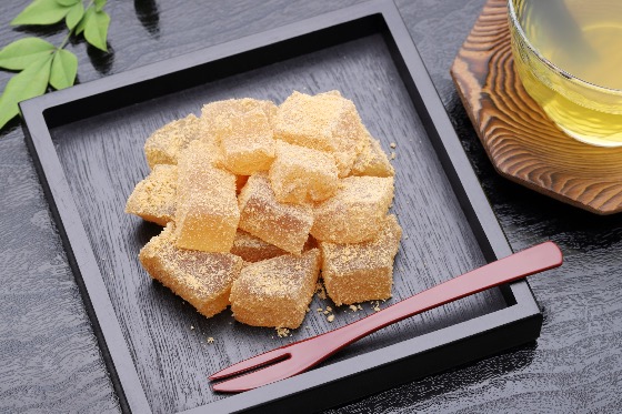 Tray of warabimochi dusted with kinako powder, served with green tea.