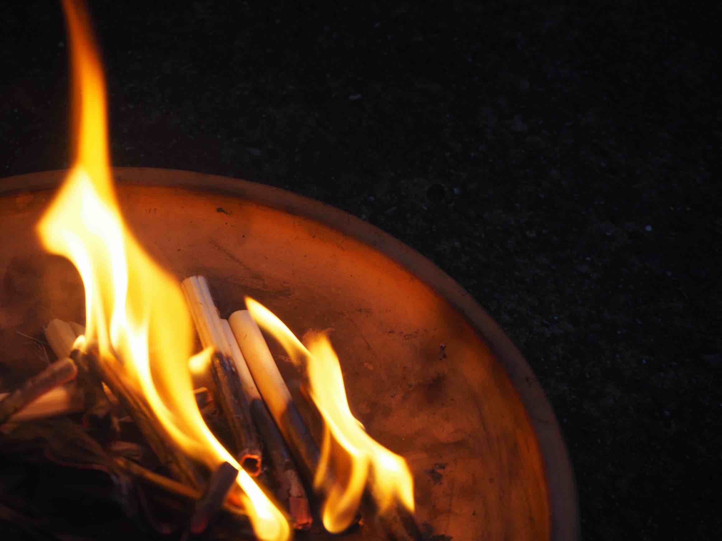 A welcoming fire burning in a small metal brazier during Obon, symbolically guiding spirits home.