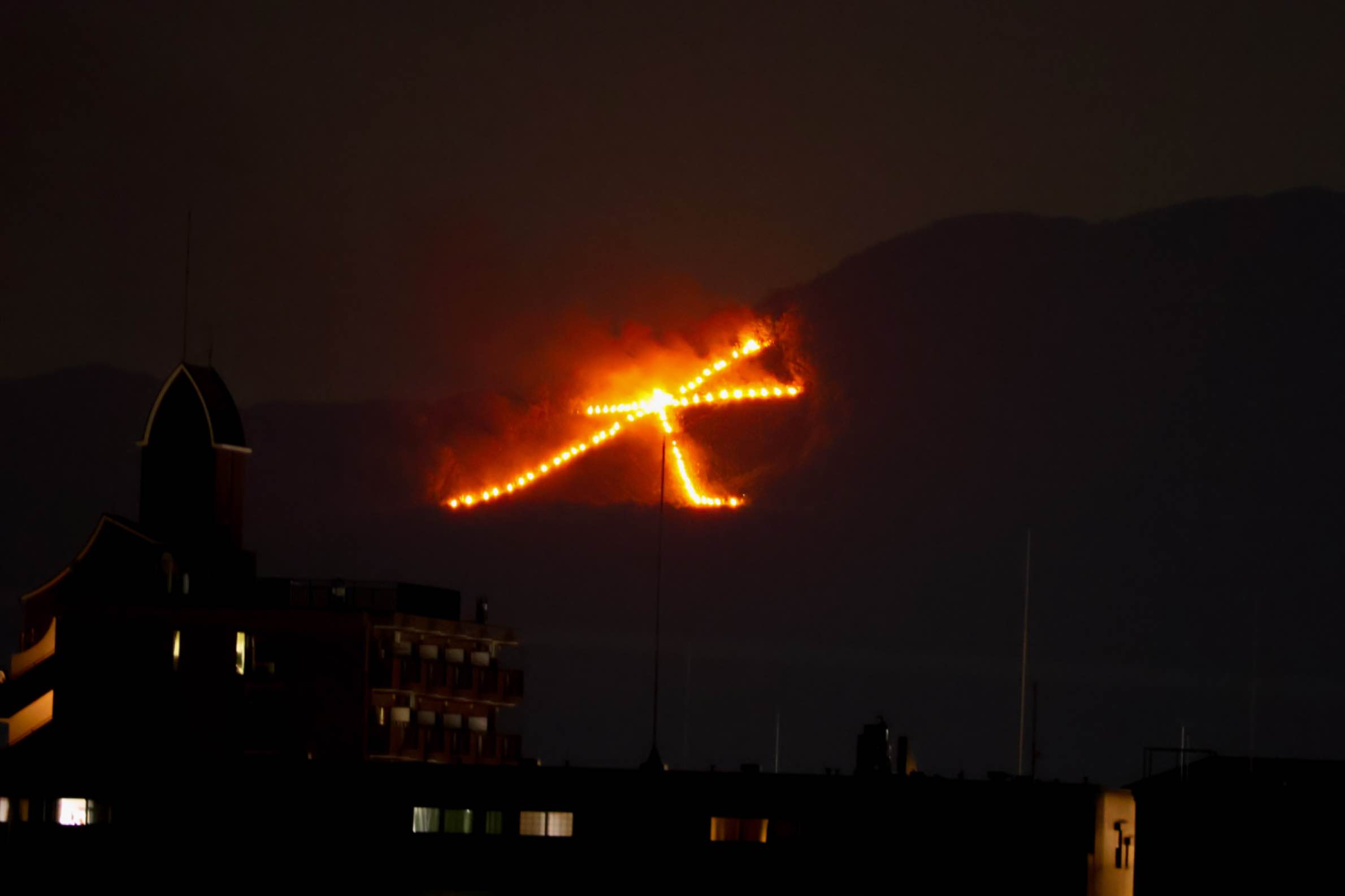 The giant kanji character “大” (dai burns on a Kyoto hillside during Gozan no Okuribi.