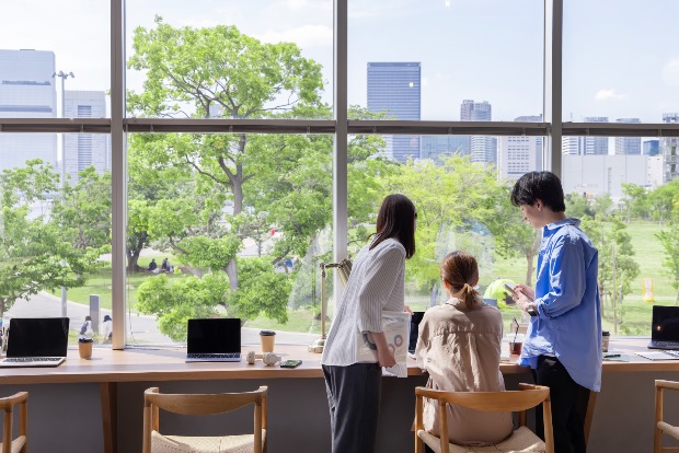 Bright coworking space in Tokyo with wide windows and people collaborating at desks.