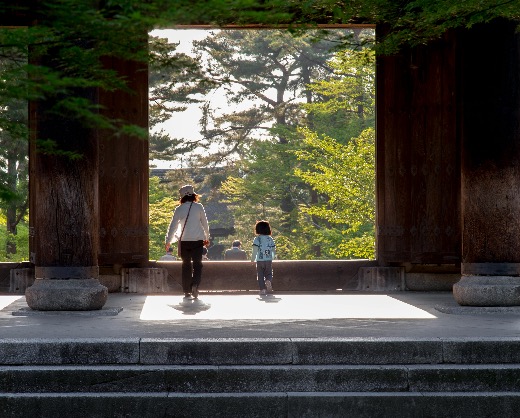 Adult and child walking through a temple gate in Japan, symbolizing the transition into the New Year.