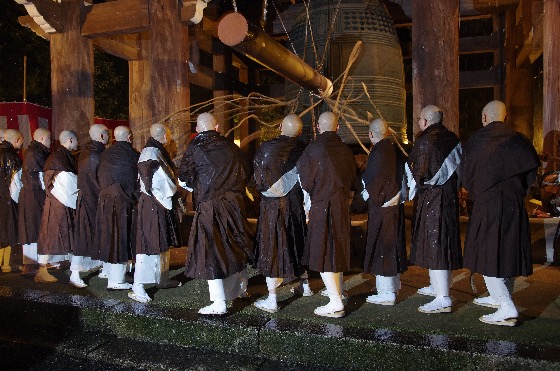 Buddhist monks ringing a large temple bell during Jōya no Kane on New Year’s Eve in Japan.