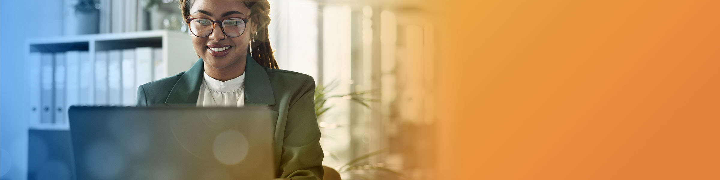 Two African American business professionals high-fiving in their office common space. 
