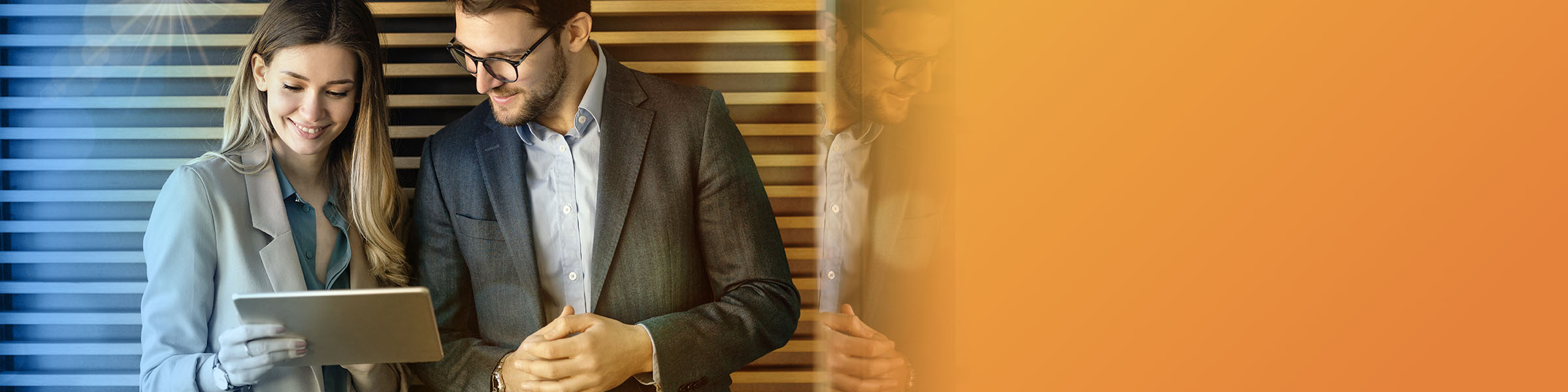 Two African American business professionals high-fiving in their office common space. 