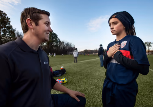 Chase Curtiss does a sideline assessment with young female athlete