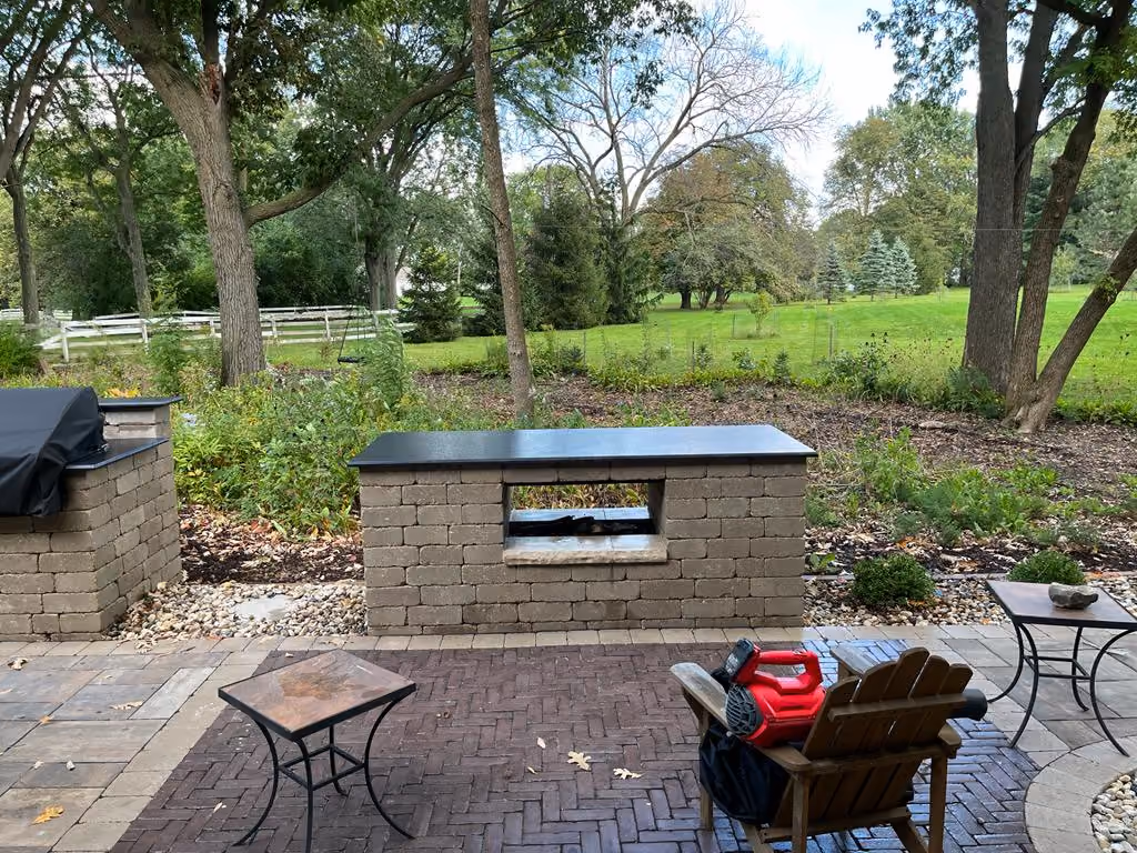 Spacious outdoor kitchen featuring a granite countertop, built-in grill, and seating area in Highland Park, IL. Marble And Granite Tech