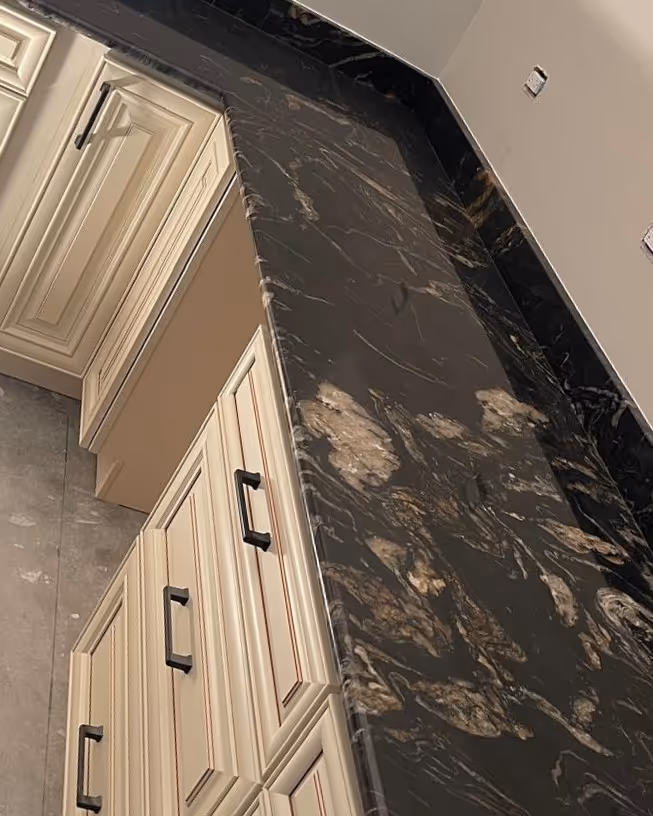 Corner kitchen setup with titanium granite countertops and cream shaker cabinets in a Chicago