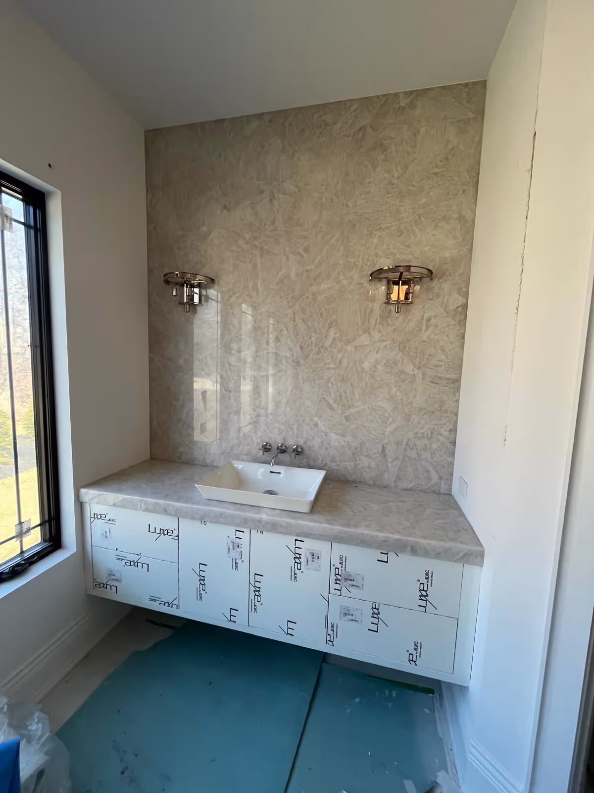 Bathroom renovation in Oak Brook featuring Pure Clear Natural Quartz used on the vanity top and matching backsplash wall.