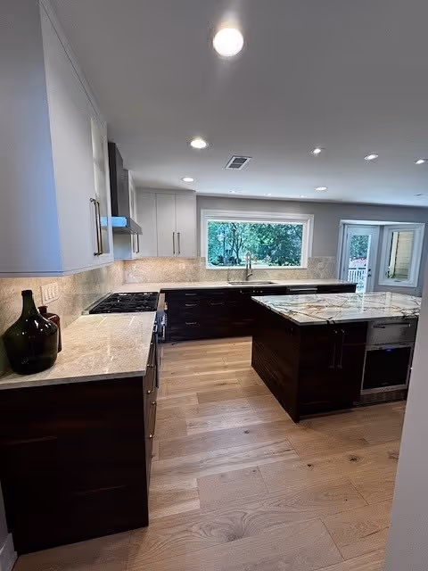 Contemporary kitchen featuring Taj Mahal Quartzite perimeter countertops and a Desert Lake Quartzite island for an elegant contrast.