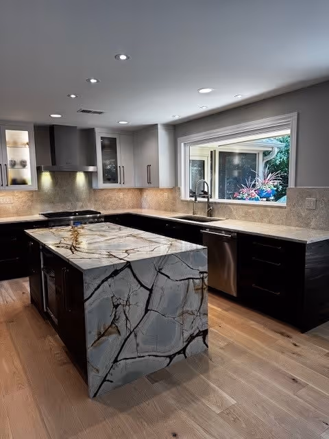 Bold waterfall island made from Desert Lake Quartzite with dramatic veining, paired with natural wood cabinetry in a modern kitchen.