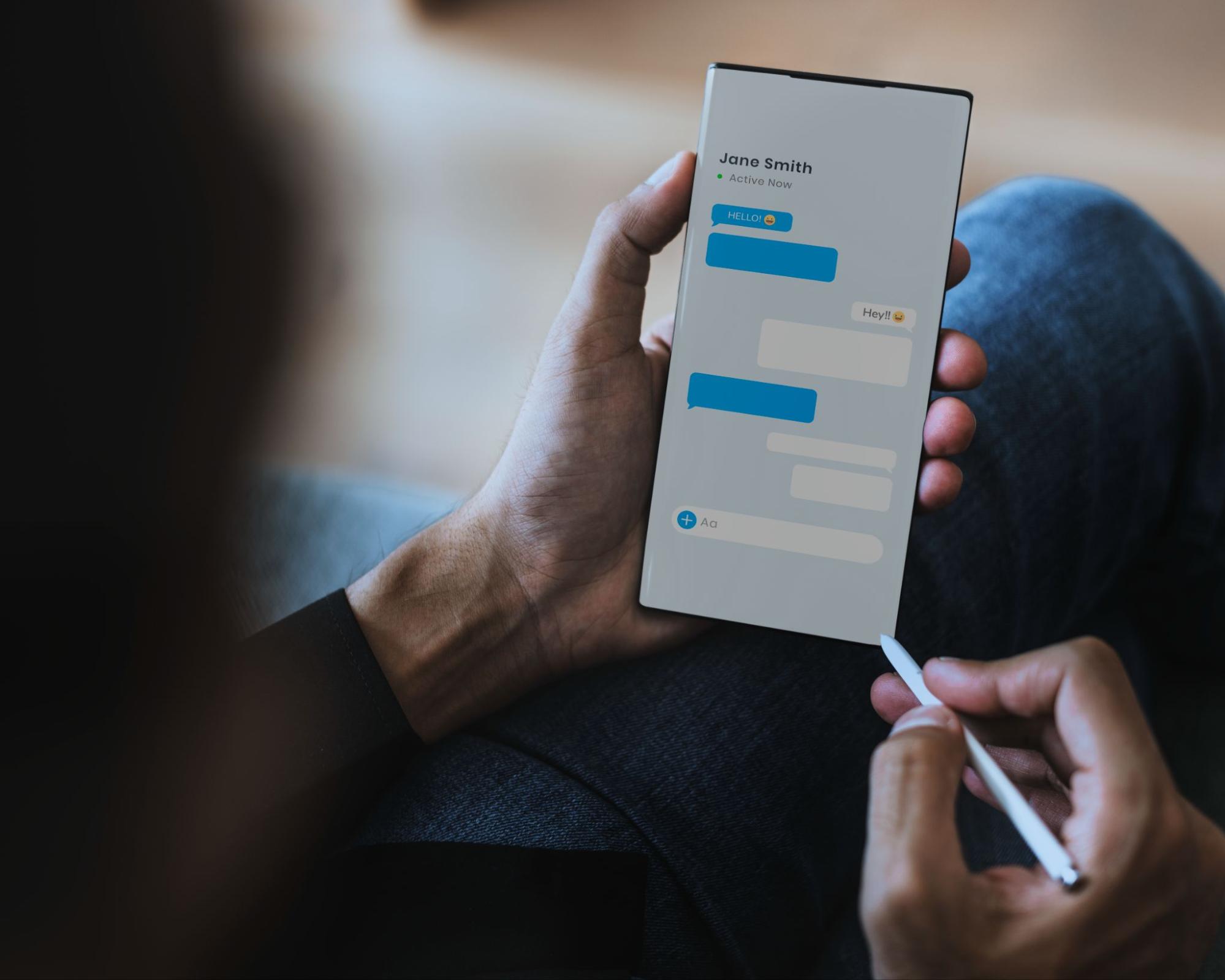Person holding a smartphone showing a private messaging conversation with chat bubbles and active status indicator
