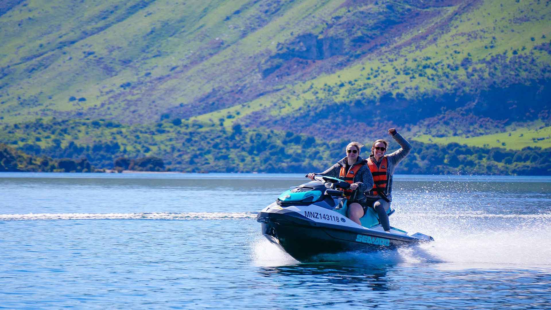 Two women racing around on a Jet Ski 