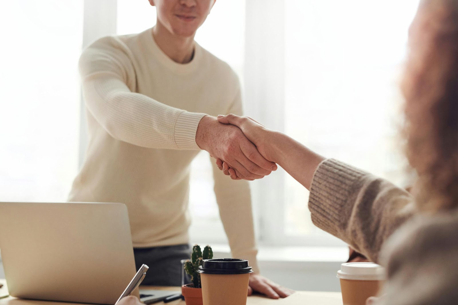 Man and Woman shaking hands over table