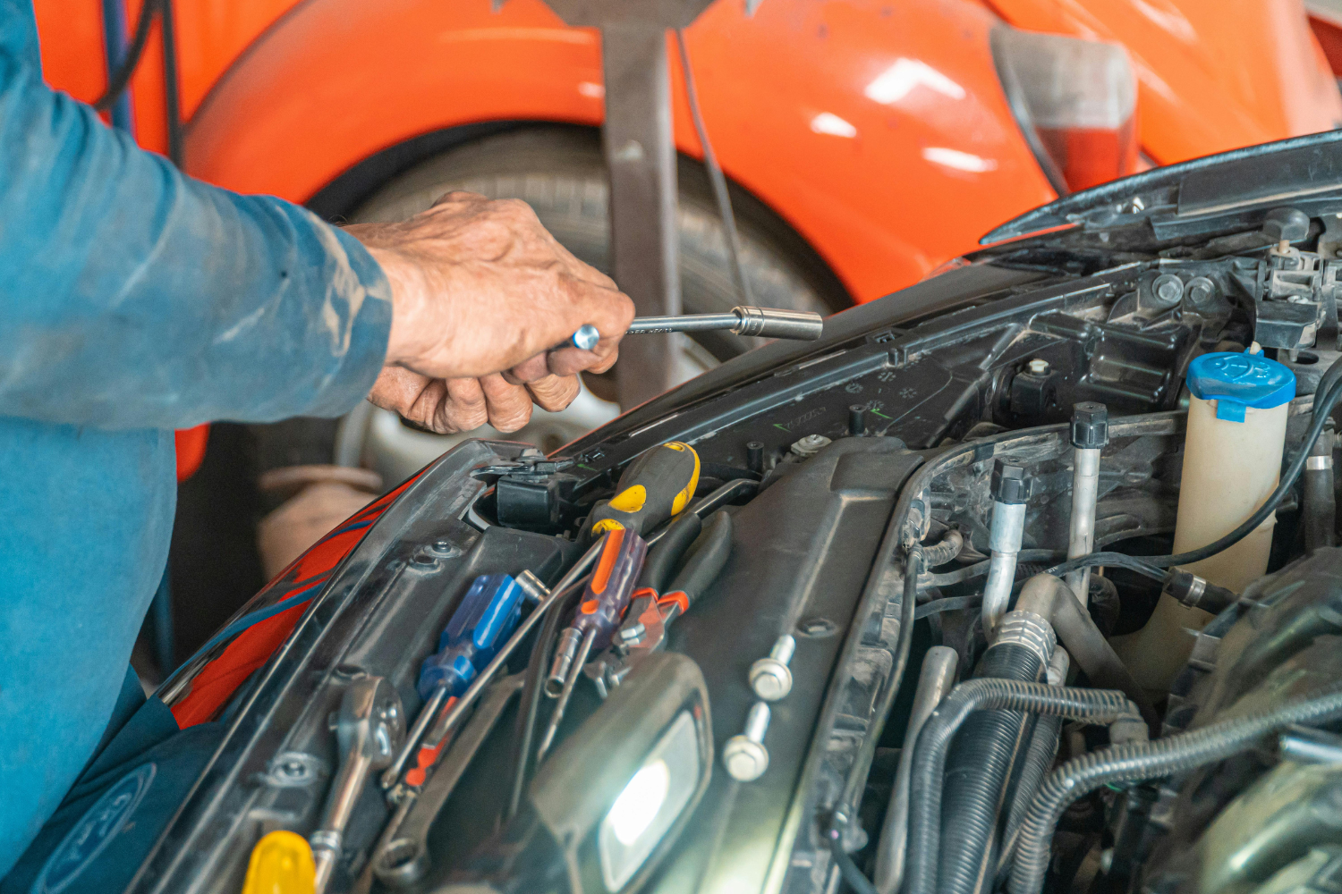 A technician working on the engine of a car.