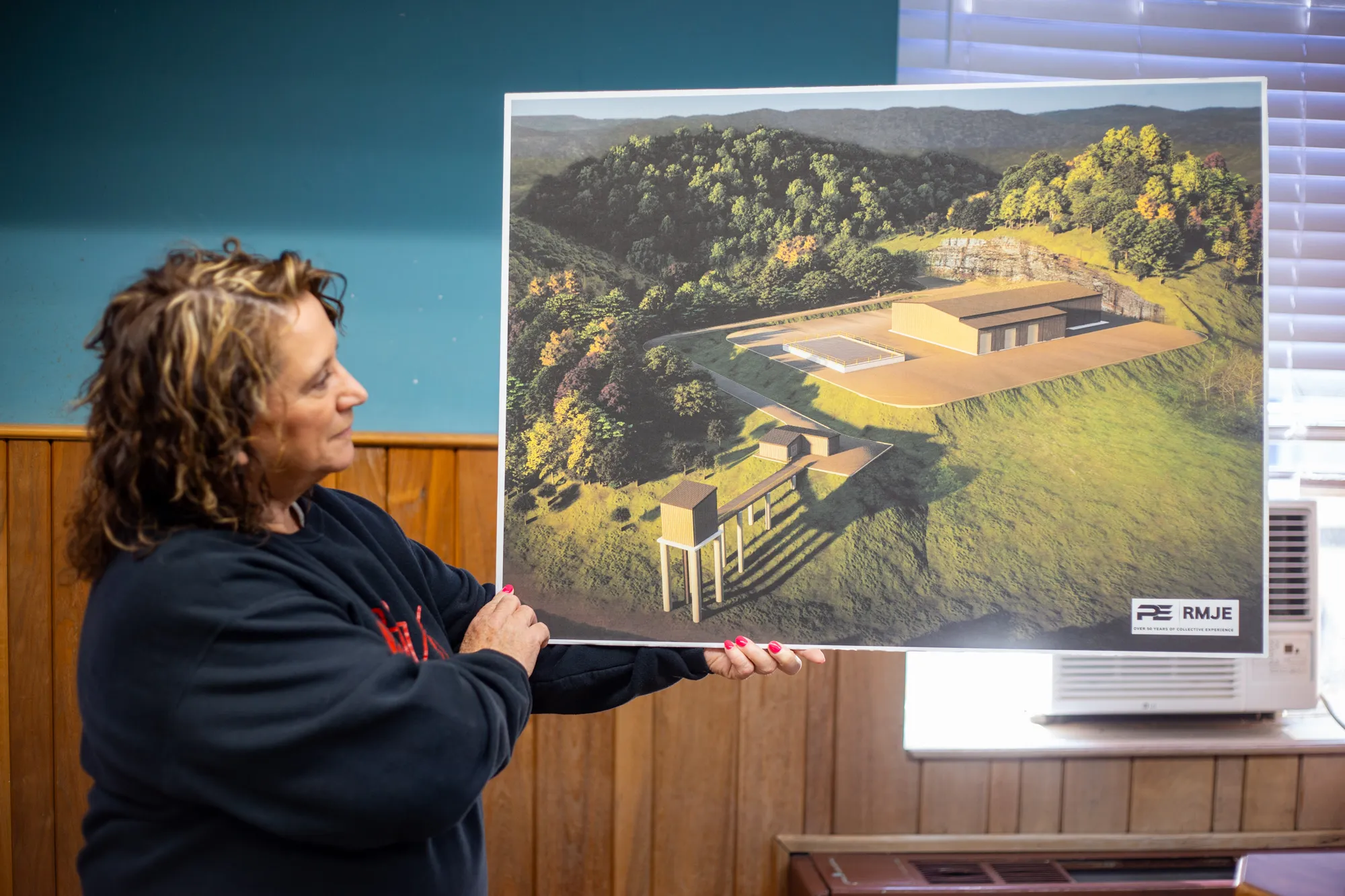 Angelia Hall, Grants Coordinator for Perry County Fiscal Court, displays plans for the new Buckhorn water project, a long-anticipated project that will bring treatment capacity closer to the communities that have historically waited the longest for service