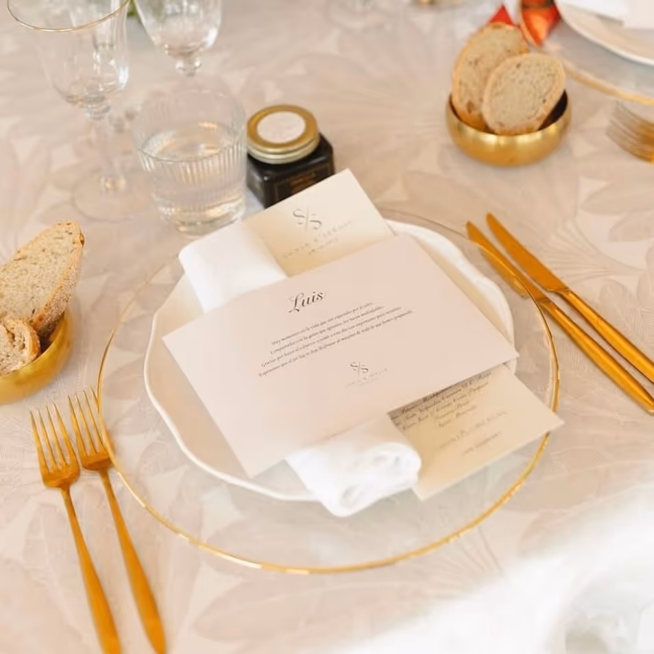 Elegante configuración de mesa con menú, pan y cubiertos dorados