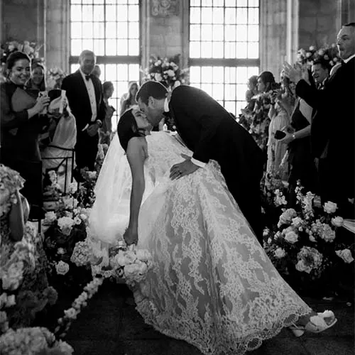 Pareja de novios besándose mientras el novio sostiene a la novia en sus brazos durante la ceremonia de boda celebrada en la Finca de Soto de Viñuelas.