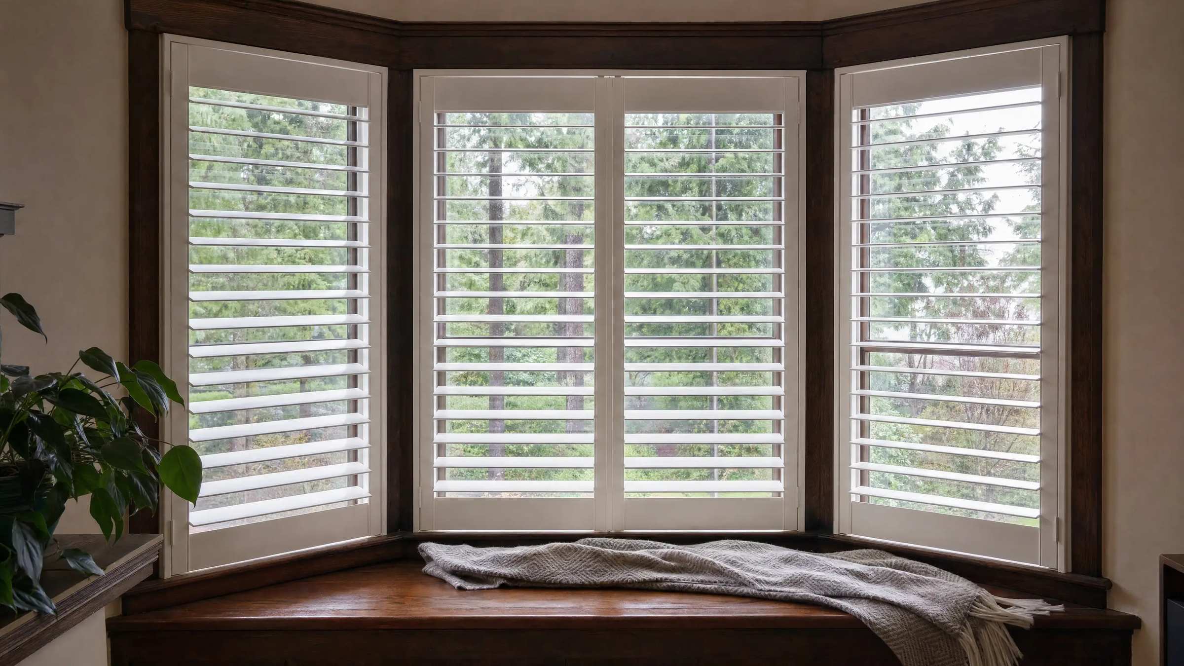 White plantation shutters in the bay window of an older Seattle craftsman home