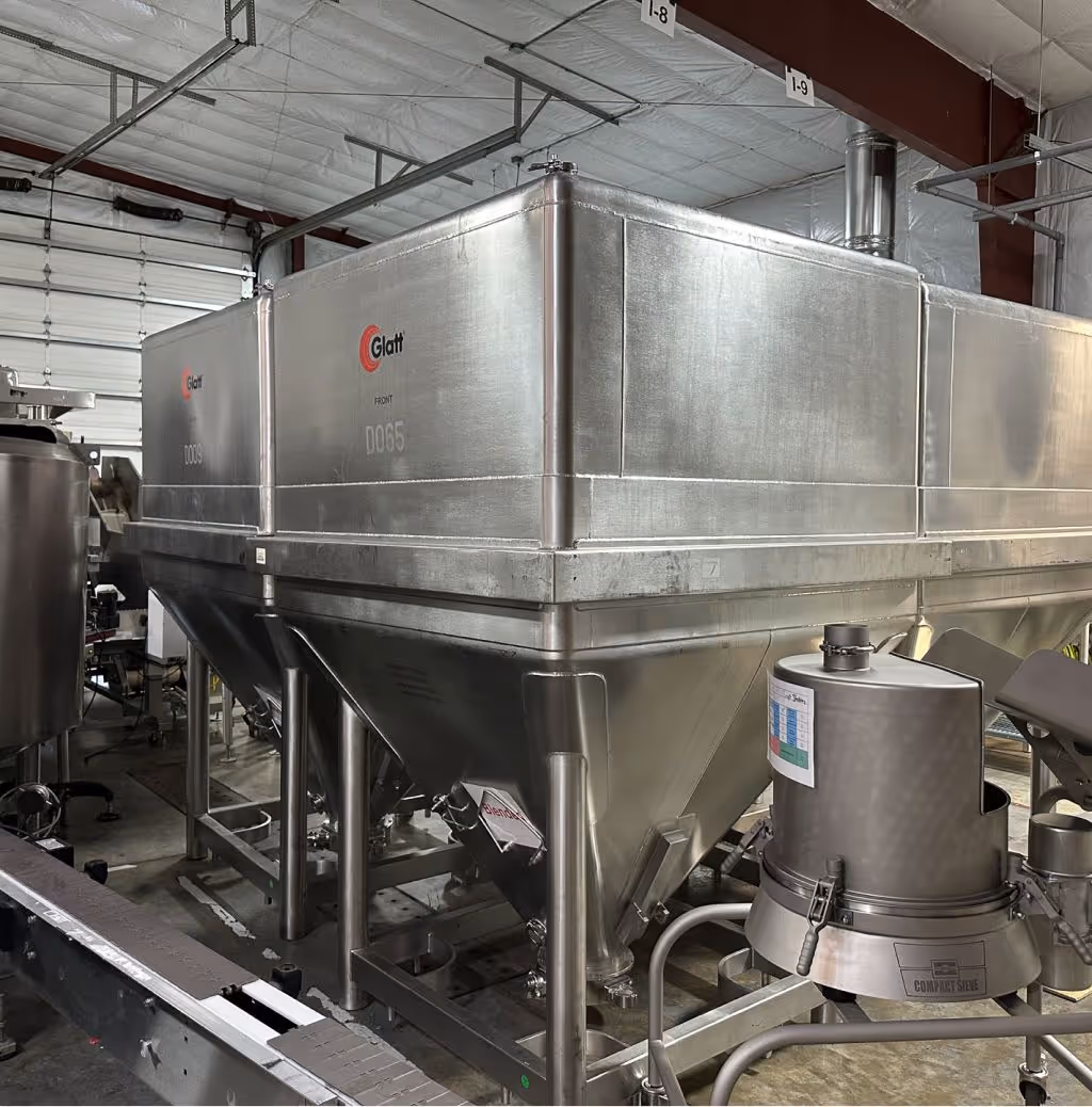 Large stainless steel industrial hoppers for blending and storing powdered supplement ingredients in nutraceutical production facility | Steuart Nutrition