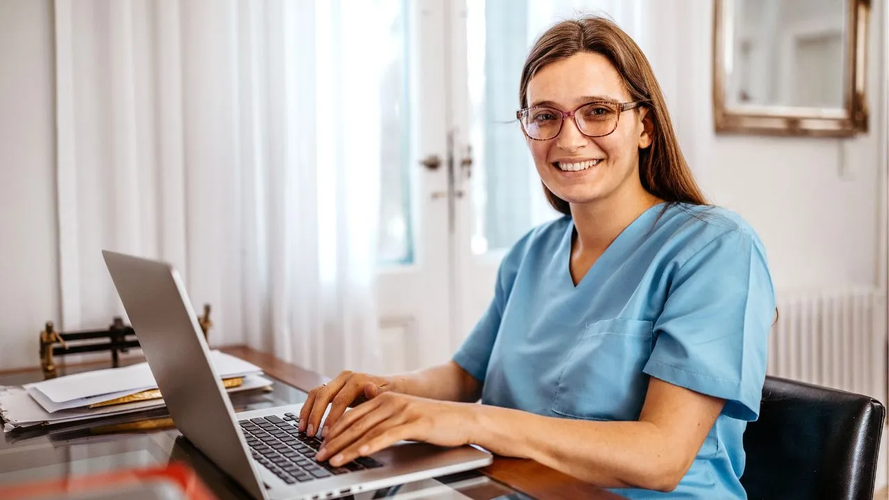nurse working from home at laptop computer
