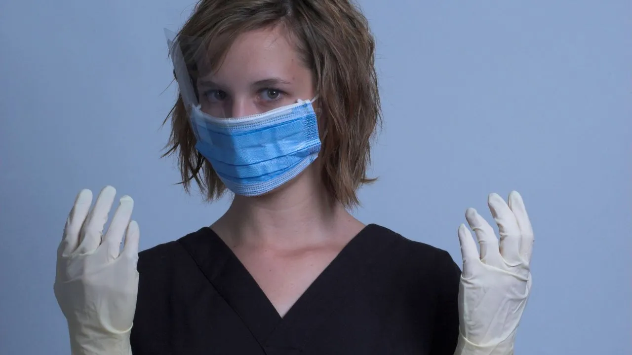 A nurse holding up their gloved hands