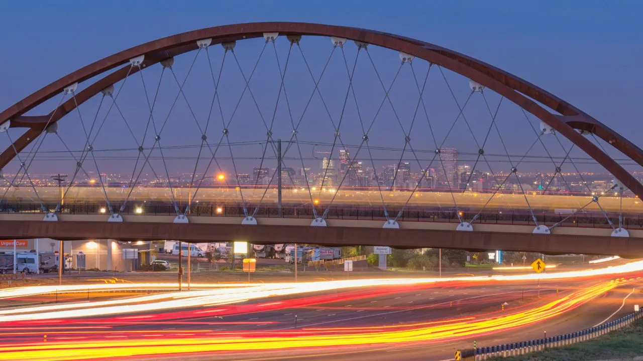an over pass with lit highways below and the citie in the back drop 