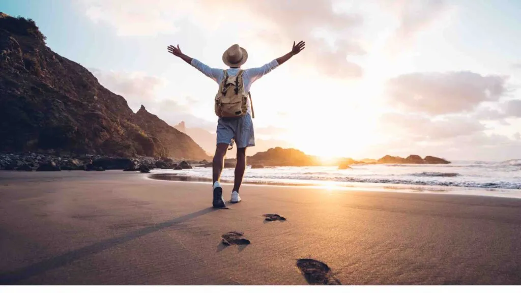 guy raising hands at beach