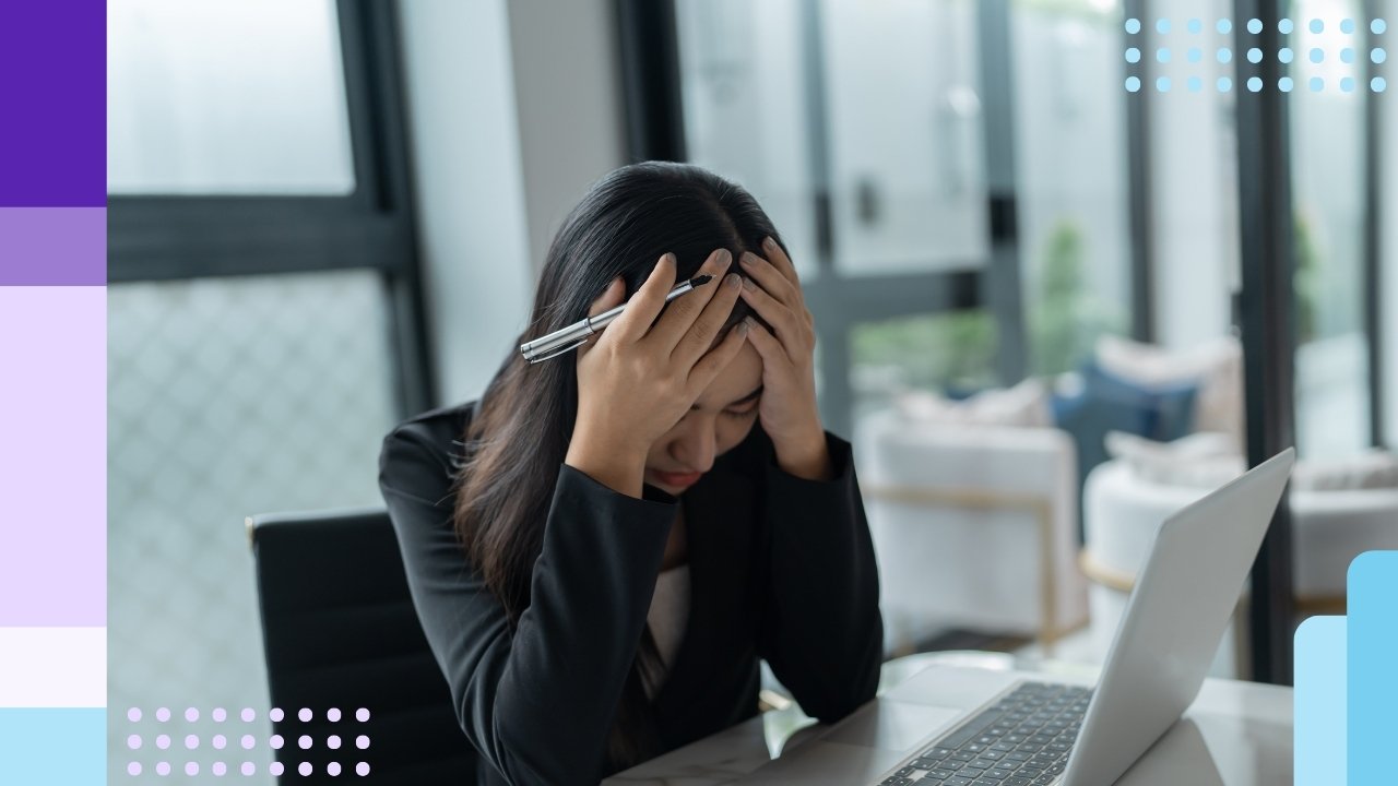 A frustrated office worker with their head in their hands
