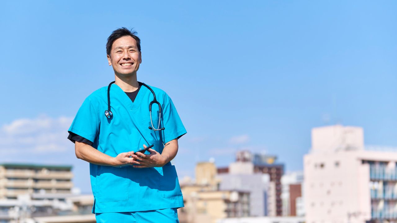 male nurse in front of a view of buildings 