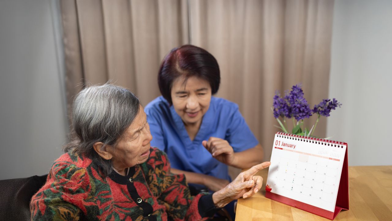 a nurse with an elderly woman pointing at a calendar
