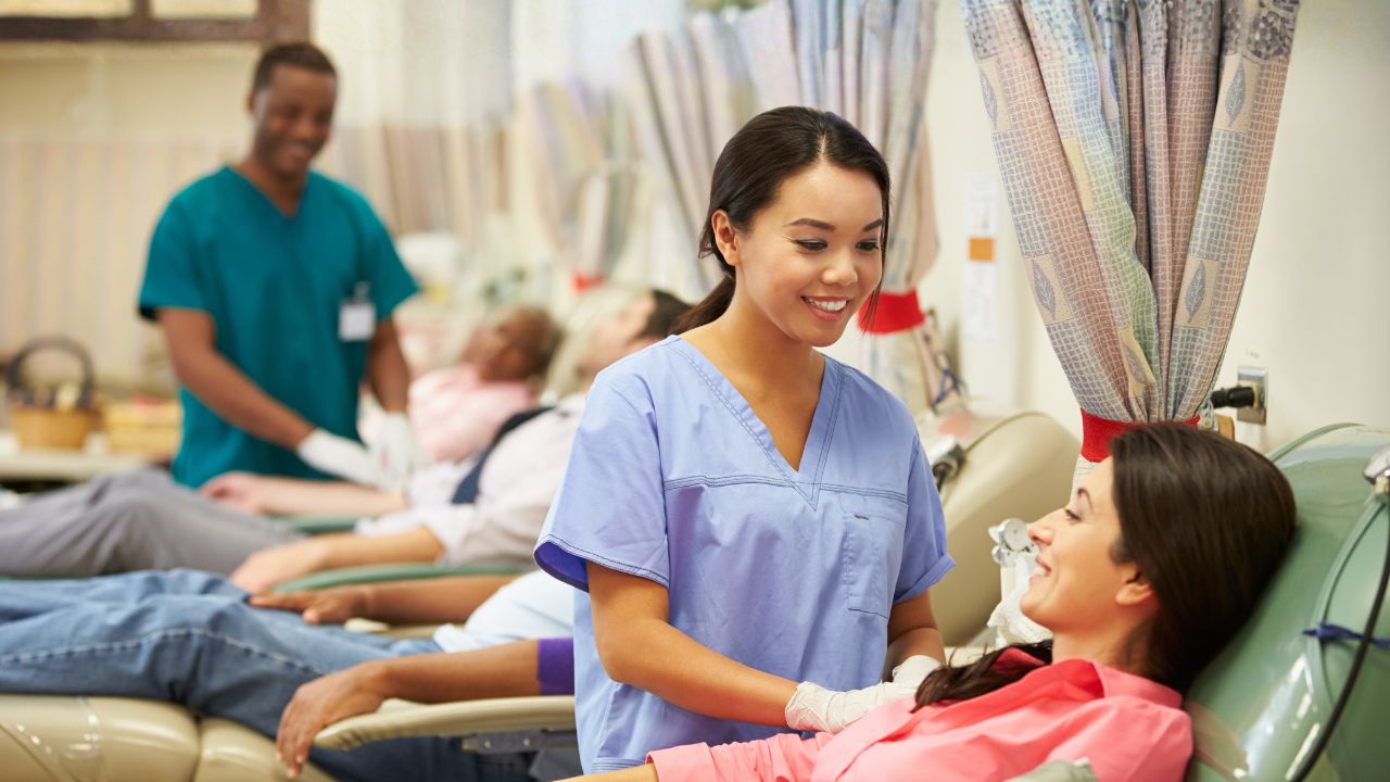 a nurse with a patient donating blood in a clinical setting